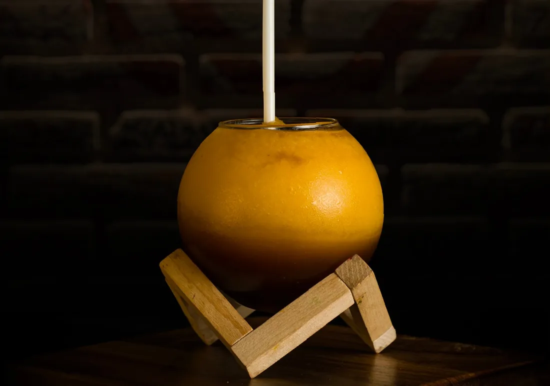 Bebida Black Melon en vaso redondo sobre base de madera