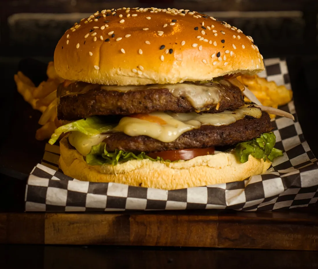 Bantha Burger doble con papas sobre papel de cuadros