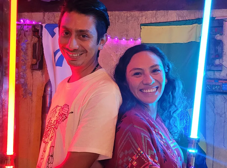 Pareja sonriendo entre un sable rojo y uno azul