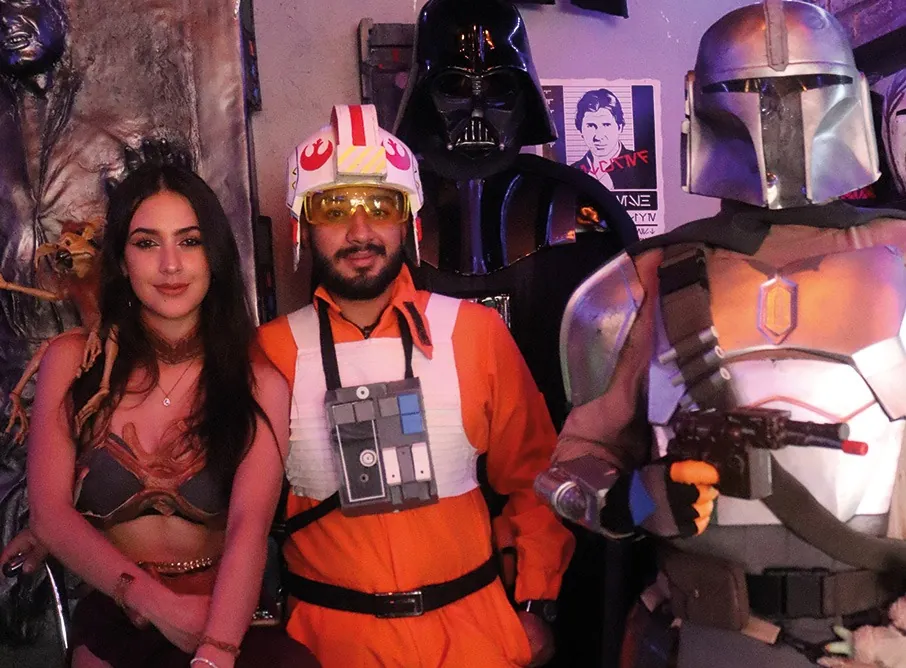 Visitante con un piloto rebelde de traje naranja y un mandaloriano