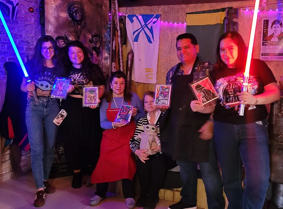 Asistentes de un taller de pintura con sus cuadros