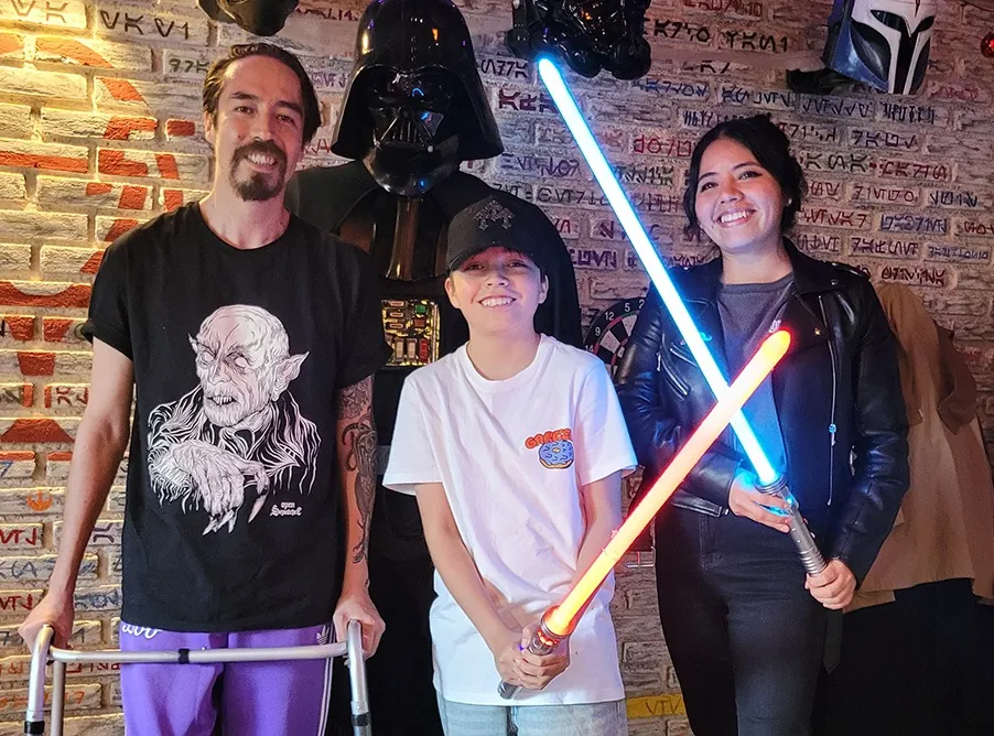 Tres amigos con sables azul y naranja, con Darth Vader detrás